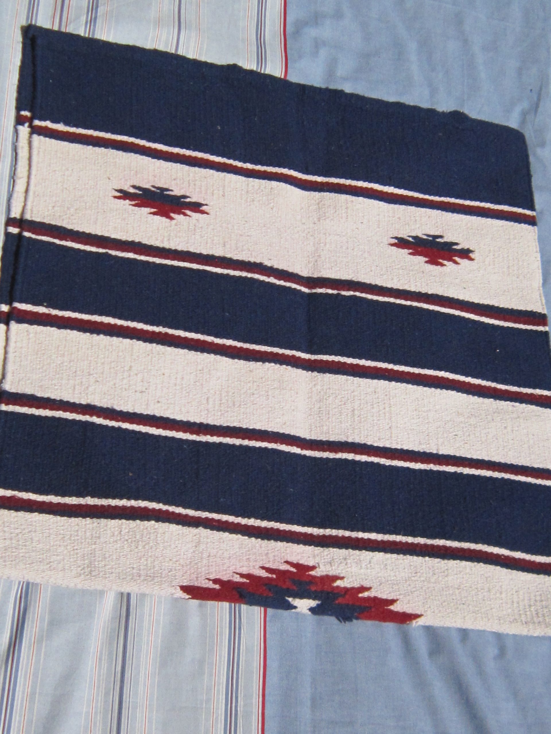 Wstern saddle blanket with navy, white and red design, folded in half