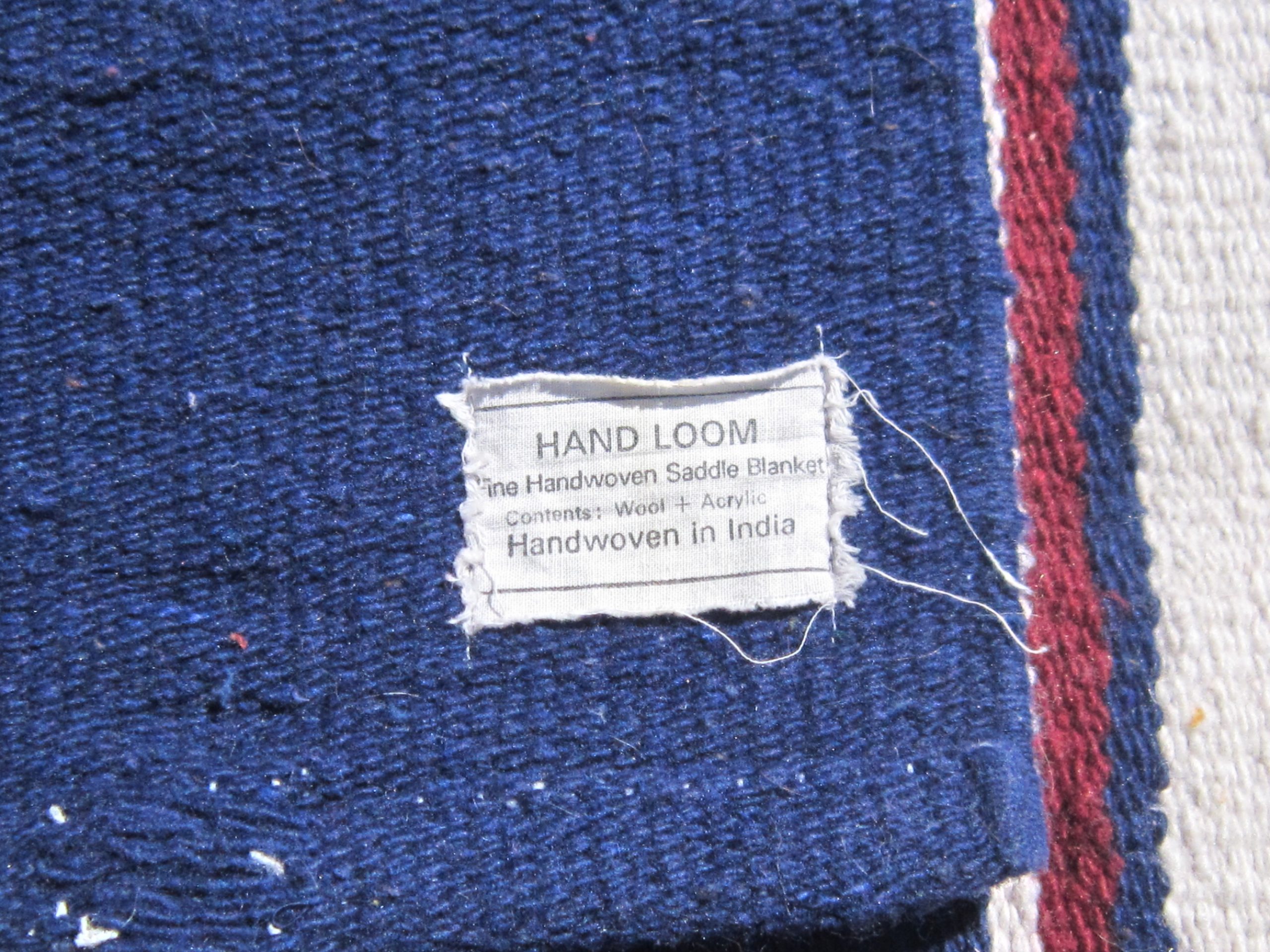 Western saddle blanket tag reading "Handwoven in India"